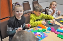 Chłopczyk i dwie dziewczynki pracujące nad pracą plastyczną 
