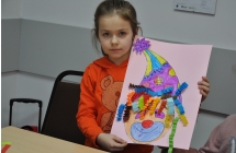 Dziewczynka prezentująca swoją prace plastyczną 