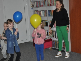 Troje przedszkolakow i kobieta z balonami