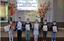 szescioro dzieci trzyma dyplomy w sali widowiskowej 