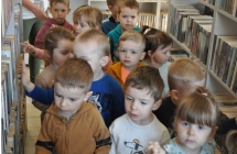Grupa dzieci posród regałó z książkami