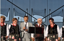 Dwoje mężczyzn w towarzystwie pań z zespołu ludowego 