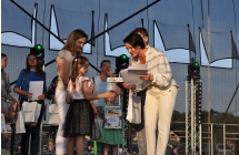 Kobiety wręczające na scenie nagrody dla dziecka i jego mamy 