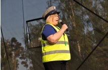Kobieta w stroju policjanta z mikrofonem na scenie 