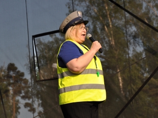 Kobieta w stroju policjanta z mikrofonem na scenie 