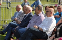 Mężczyźni siedzący na ławce przed sceną 