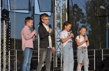 Dwie dziewczynki i dwoje chłopców wykonują piosenkę na scenie 