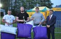 Nagrodzeni w konkursie sportowym wraz z mężczyzną w garniturze 