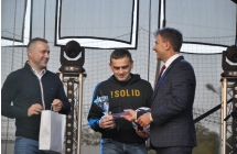 Troje mężczyzn na scenie podczas wręczania nagród za osiągnięcia sportowe 