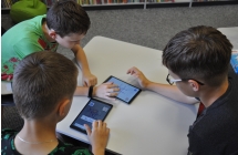 Trójka chłopców grających w kółko i krzyżyk na tabletach 