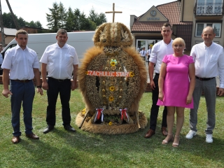 Czworo mężczyzn i kobieta przy wieńcu dożynkowym 