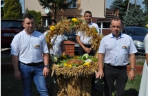 Troje elegancko ubranych mężczyzn i wieniec dożynkowy 