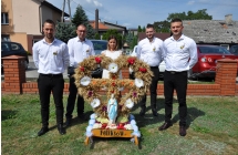 Czterech mężczyzn i kobieta przy wieńcu dożynkowym 