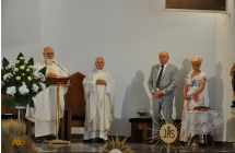 Dwoje księży i starostowie dożynek w kościele 