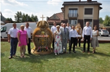 Kilkunastoosobowa delegacja wieńcowa przy okazałym wieńcu 