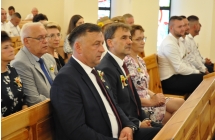 Mężczyźni w garniturach i wierni w kościelnych ławkach 
