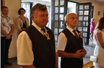 Dwoje mężczyzn w kościele. W tle inni wierni 