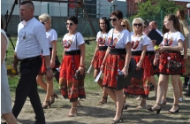 Kobiety idące w korowodzie ubrane w ludowych strojach 