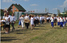 Kilkadziesiąt osób idących w korowodzie dożynkowym 
