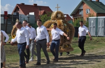 Kilkoro mężczyzn niosących wieniec dożynkowy 