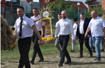 Mężczyźni na placu dożynkowym niosący wieńce 