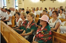 Kobiety w ludowych strojach siedzące w kościele 