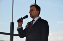 Mężczyzna na scenie mówiący do mikrofonu 