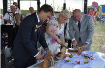 Dwoje mężczyzn i kobieta krojący chleb 