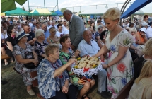 Kobieta rozdająca pokrojony, dożynkowy chleb 