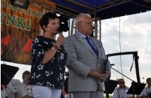 Elegancka kobieta i mężczyzna na scenie mówiący do mikrofonu ze sceny 