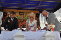 Dwoje mężczyzn i kobieta podczas uroczystego krojenia chleba 
