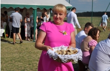 Uśmiechnięta kobieta prezentująca kosz z chlebem 