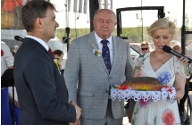 Kobieta trzymająca chleb i dwoje mężczyzn stojących obok niej na scenie 