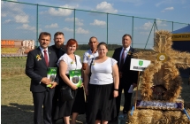 Czterech mężczyzn i dwie kobiety przy wieńcu dożynkowym 