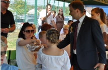 Mężczyzna częstujący gości chlebem dożynkowym 