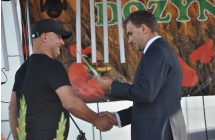 Mężczyzna podający drugiemu dyplom 
