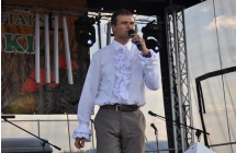 Chłopak w wyjątkowej koszuli śpiewający na scenie 