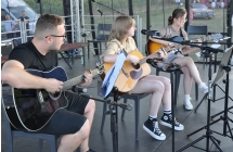 Trio muzyczne - mężczyzna i dwie dziewczyny grające na gitarze