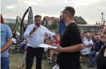 Mężczyzna z mikrofonem i drugi mężczyzna trzymający notatki 