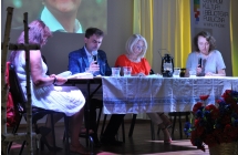 Trzy kobiety i mężczyzna siedzących przy stole na scenie 