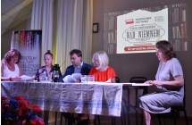Cztery kobiety i mężczyzna siedzący przy stole na scenie 