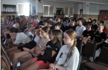 Licznie zebrana publiczność na sali widowiskowej patrząca w tym samym kierunku