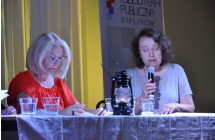 Dwie skupione kobiety. Jedna czyta do mikrofonu tekst 