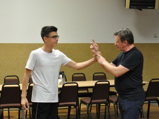 Mężczyzna i chłopiec podczas prezentowania kursu samoobrony 