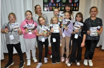Grupa dziewczynek wraz z kobietą, dzieci trzymają dyplomy 