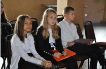 Dwie dziewczynki i chłopiec. Siedzą na krzesełkach na sali widowiskowej 