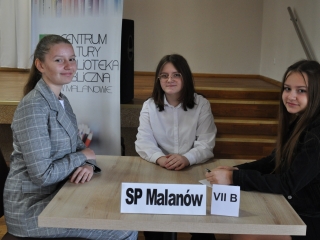 Trzy dziewczynki siedzące przy stoliku 