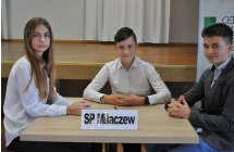 Dziewczynka i dwoje chłopców siedzących przy stoliku 