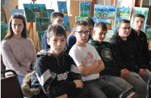 Uczniowie siedzący na krzesłkach na sali widowiskowej 