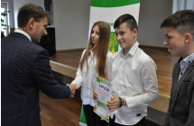 Mężczyzna podający dłoń dziewczynce. Obok niej dwoje chłopców. Wszyscy elegancko ubrani 